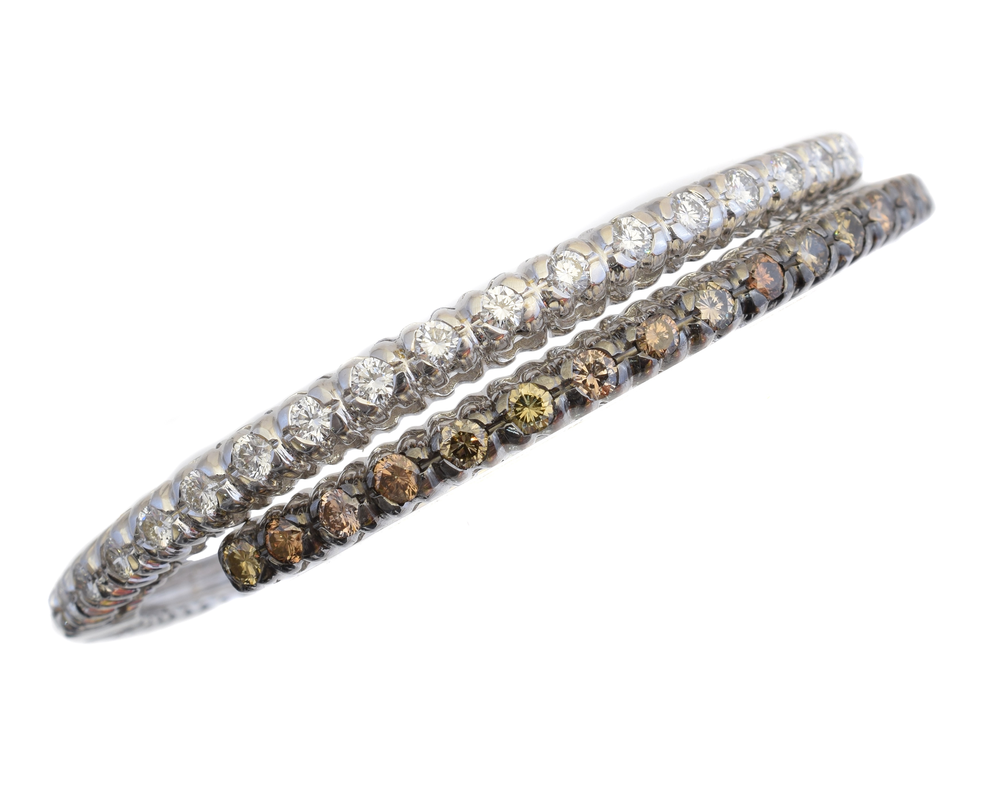 An 18ct gold diamond hinged bangle, the brilliant cut diamond and similarly cut 'brown' diamond crossover lines with plain reverse, estimated total diamond weight 2.80cts, Italian assay marks, inner diameter 5.7cm, gross weight 22.3g.