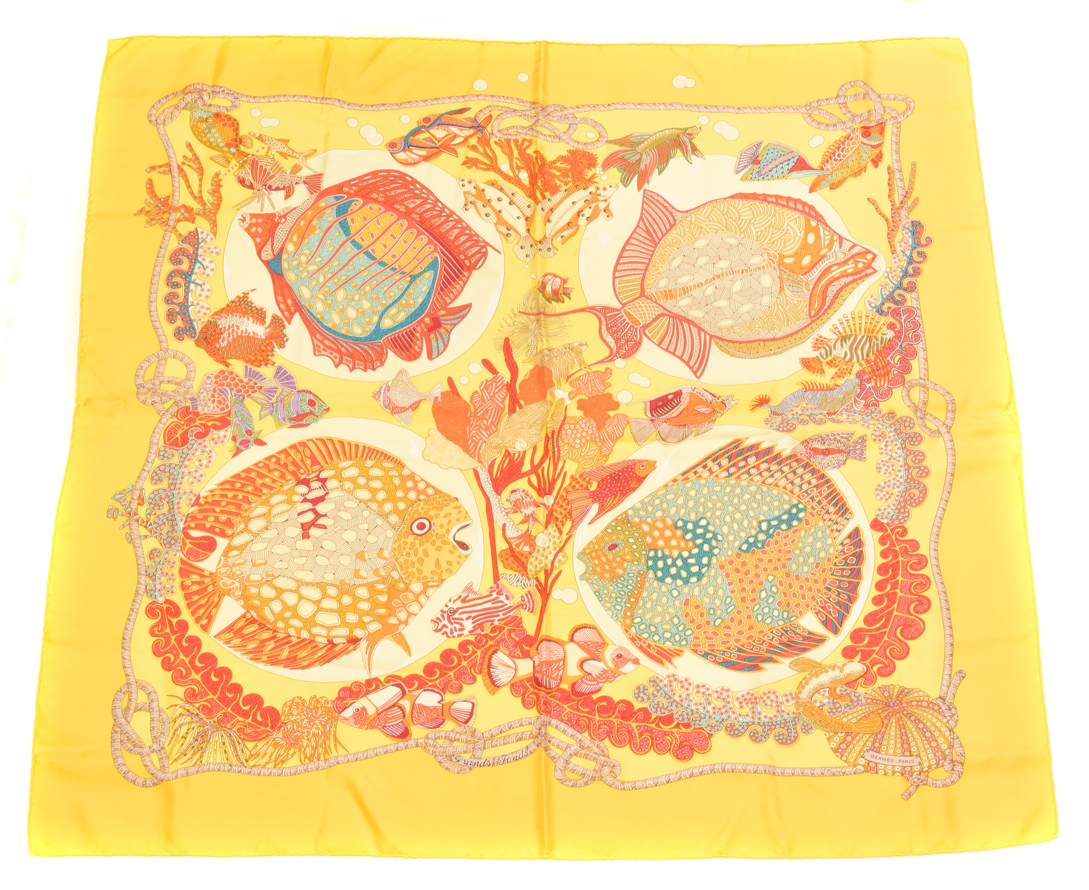 A Hermès "Grand Fonds" silk scarf by Annie Faivre, circa 1992, the yellow, orange, blue and purple pattern depicting exotic fish, signed Hermès. With maker's box.