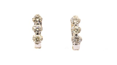 Lot 110 - A pair of 18ct gold diamond hoop earrings