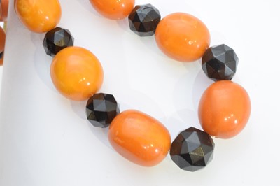 Lot 184 - A butterscotch amber and jet necklace.