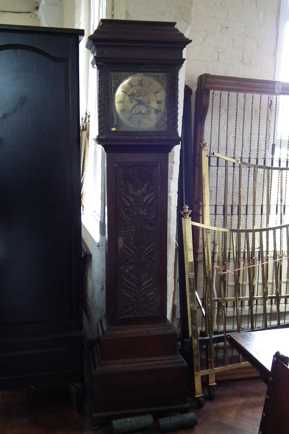 Lot 134 - Longcase clock by Wooley with brass dial and carved oak case.