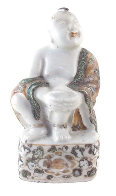 Lot 176 - Chinese figure of a seated boy in a Wucai robe