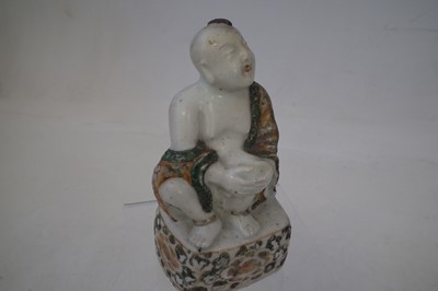 Lot 176 - Chinese figure of a seated boy in a Wucai robe