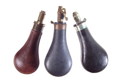 Lot 214 - Three leather and brass powder flasks