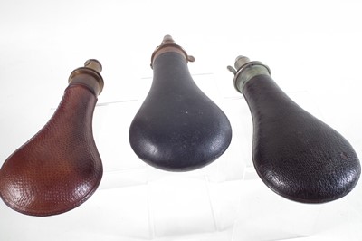 Lot 214 - Three leather and brass powder flasks