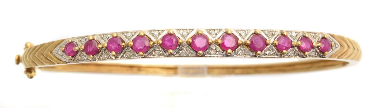 Lot 9 - A ruby and diamond hinged bangle