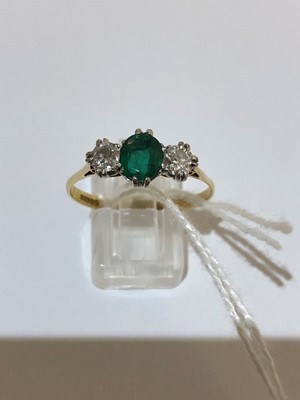 Lot 64 - An 18ct gold emerald and diamond three stone ring