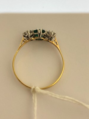 Lot 64 - An 18ct gold emerald and diamond three stone ring