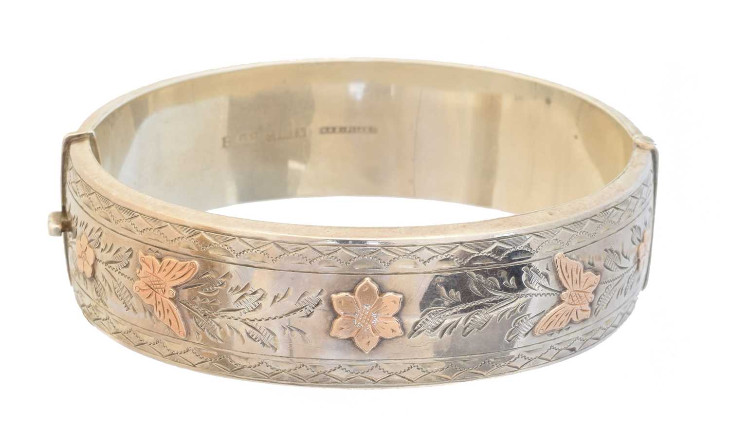 Lot 9 - A silver and gold hinged bangle by Deakin & Francis