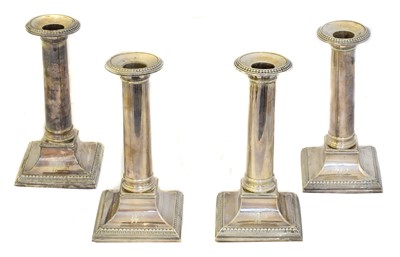 Lot 145 - Four George III silver candlesticks