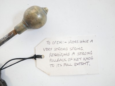 Lot 240 - Pair of hand cuffs and a bar lock (lacking the...