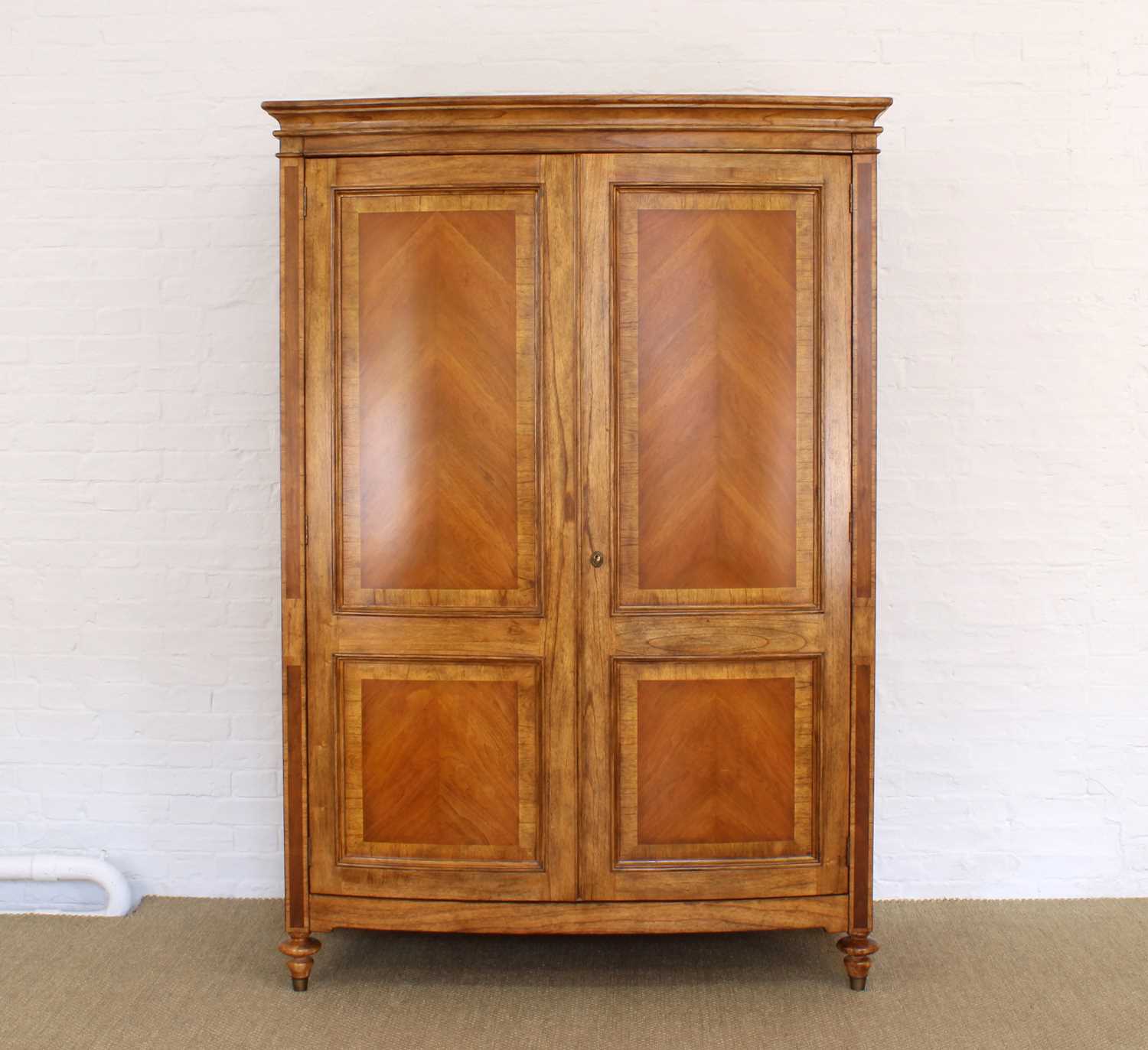 Lot 176 - A Walnut Bowfront Wardrobe from the "Spire" Range by Frank Hudson Ltd.