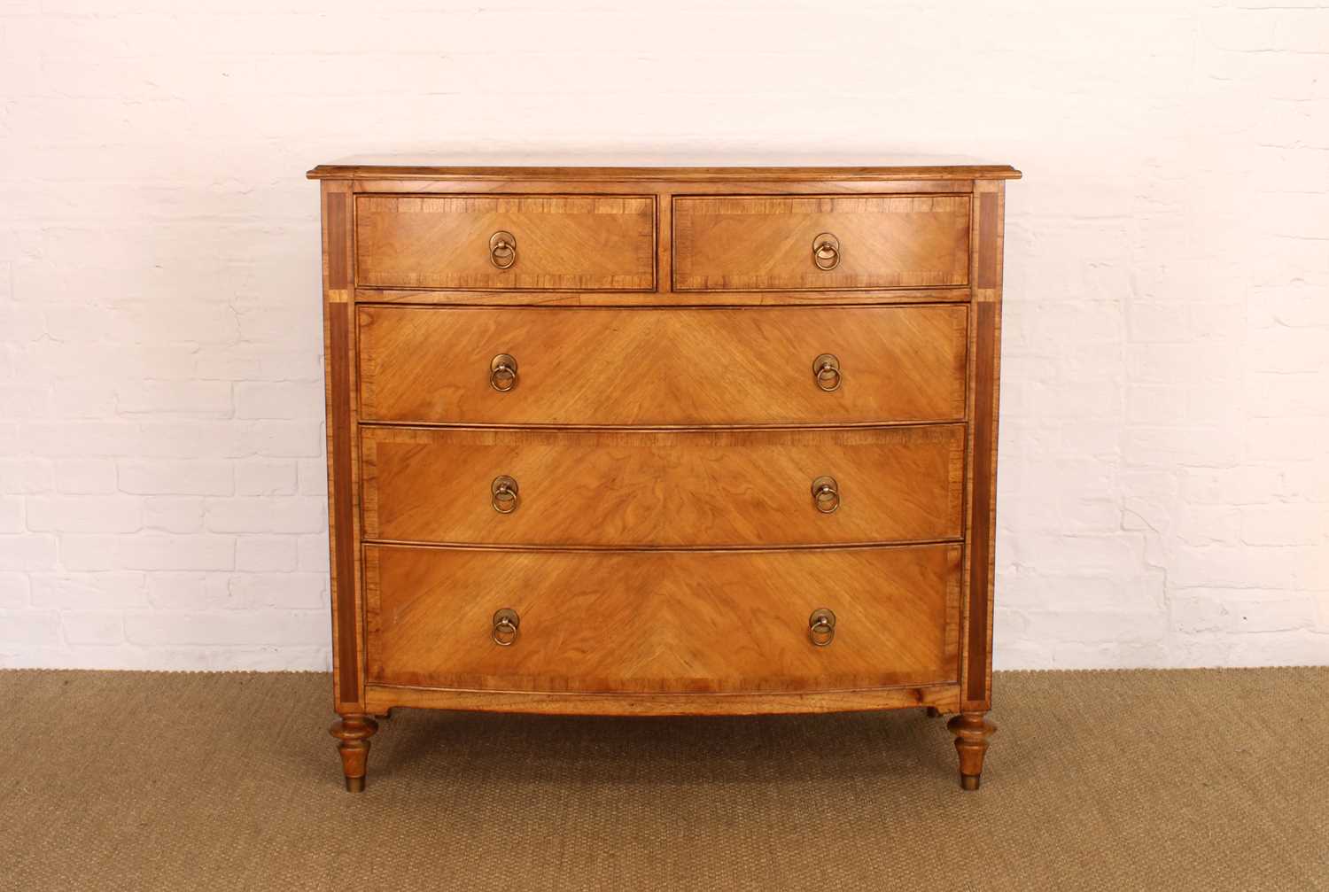 Lot 177 - A Walnut Bowfront Chest of Drawers from the "Spire" Range by Frank Hudson Ltd.