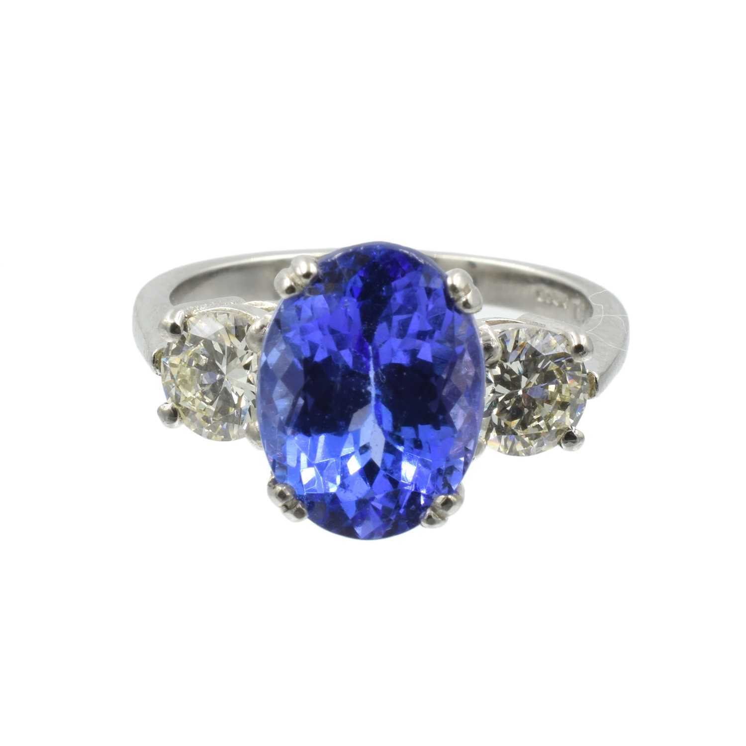 Lot An oval cut tanzanite and diamond 3 stone ring set in platinum