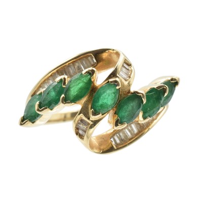 Lot 107 - An emerald and diamond "ribbon" ring set in 14ct yellow gold