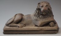 Lot 180 - Stoneware model of a recumbent lion   with bronze