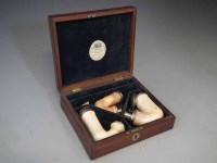 Lot 10 - Figured mahogany box with brass inlay lid with paper label F Pontet Pipers London, the blue velvet lined fitted interior containing three Meerschaum