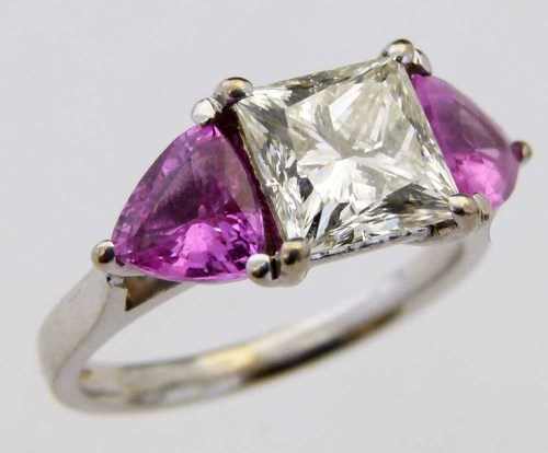 Lot 262 - Pink sapphire and princess cut diamond three stone ring