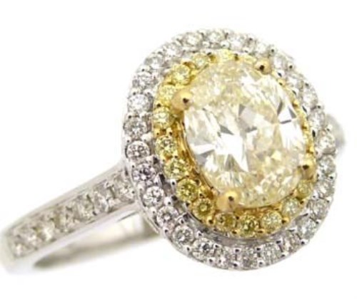 Lot 321 - Fancy yellow diamond oval cluster ring
