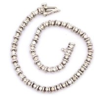 Lot 385 - 18k white gold and diamond line bracelet of