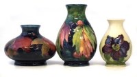 Lot 197 - Three Moorcroft vases decorated with pomegranate, leaf and berry and clematis pattern.