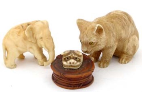 Lot 419 - Japanese ivory netsuke of a cat with yellow glass