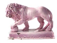 Lot 216 - Pottery lion decorated with a pink lustre glaze