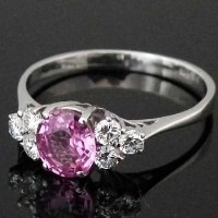 Lot 288 - Oval pink sapphire, 1.39ct, flanked by six