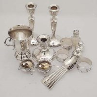 Lot 421 - Group of silver; pair candlesticks, squat candlestick, three napkin rings, pair salts, 5 tea spoons, pair peppers and shaker.