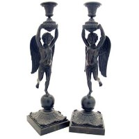 Lot 28 - Two bronze candlesticks in form on winged