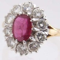 Lot 317 - Ruby and diamond oval cluster ring