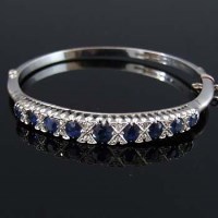 Lot 253 - Sapphire and diamond nine carat hooped bangle.