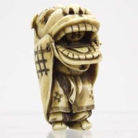 Lot 514 - Ivory Netsuke of boy in a grotesque costume.