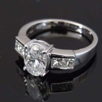 Lot 355 - Oval diamond, 1.35ct, in 18ct white gold flanked