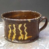 Lot 557 - 17th century slipware mug/porringer.