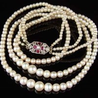 Lot 255 - Triple string cultured pearl necklace with ruby