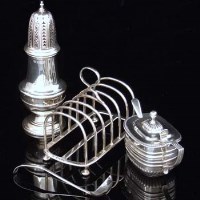 Lot 216 - Silver mustard pot, silver shaker and toast rack