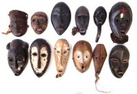 Lot 11 - Twelve African passport masks carved in various tribal styles, the largest measures 19cm high