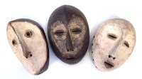 Lot 22 - Three Lega masks carved with handles to the