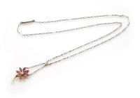 Lot 191 - An Edwardian diamond and ruby flower head pendant with small pearl dropper