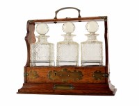 Lot 12 - An oak tantalus with three cut glass decanters