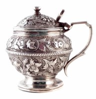 Lot 179 - Georgian circular silver mustard pot, embossed with leaf and floral decoration, hinged domed lid with button finial, raised on spreading circular foot