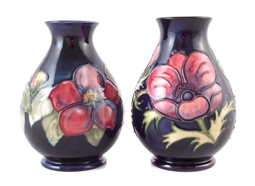 Lot 205 - Two Moorcroft vases decorated with Clematis and Anemone pattern on a blue ground, impressed marks to base, the Anemone vase has a silver line, 13.5cm high