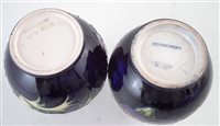 Lot 205 - Two Moorcroft vases decorated with Clematis and Anemone pattern on a blue ground, impressed marks to base, the Anemone vase has a silver line, 13.5cm high