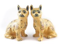 Lot 178 - A pair of Faience yellow ground cats