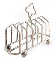 Lot 521 - A silver toast rack on four ball feet by Mappin & Webb, Sheffield